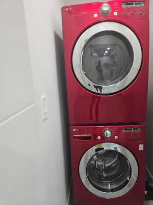 a red washer and dryer sitting next to a wall at Cy Becker Drive 2023 Luxury Home in Edmonton