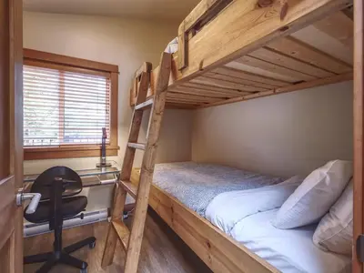 a bunk bed with a desk and a chair in a room at Going Coastal AB - Oceanfront - Pet Friendly in Port Renfrew