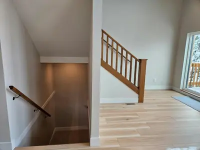 a hallway with a staircase and a wooden floor at Hot Tub - Sleep 12 - EV Charger J1772 - Forest View - Pet Friendly in Mount Washington