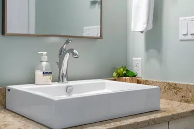 a white sink in a bathroom with a mirror at Spacious Oceanview - 2 living rooms & fridges - Pet Friendly in Port Renfrew