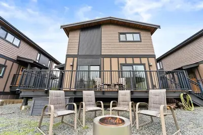 a house with a balcony with chairs and a fire pit at Spacious Oceanview - 2 living rooms & fridges - Pet Friendly in Port Renfrew