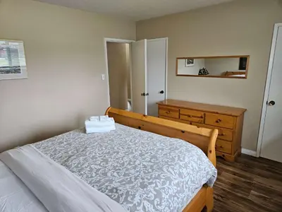 a bedroom with a bed and a dresser and a mirror at The Outfitter - Garden View - Pet Friendly - Huge yard in Port Renfrew