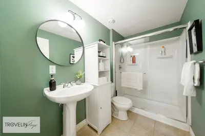 a bathroom with a sink and a toilet and a mirror at Spacious Private Apartment with King Bed, Full Kitchen and In-Suite Laundry in Edmonton