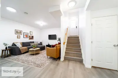 a living room with a couch and a stairway at Spacious Private Apartment with King Bed, Full Kitchen and In-Suite Laundry in Edmonton