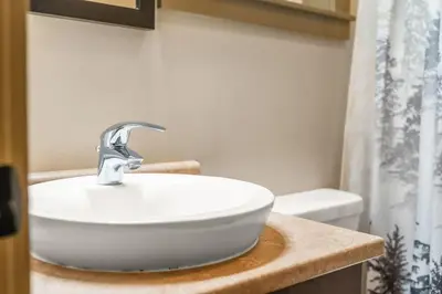 a bathroom with a white sink and a shower at JDF Waystation Cabin - Garden View - Pet Friendly in Port Renfrew