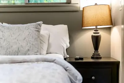 a bedroom with a bed and a lamp on a nightstand at JDF Waystation Cabin - Garden View - Pet Friendly in Port Renfrew