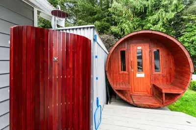 a large wooden door on a building next to a house at The Point Partial - Hot tub - Sauna - view of San Juan Bay - Pet Friendly in Port Renfrew
