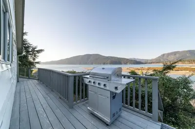 a grill on a deck with a view of the water at The Point Partial - Hot tub - Sauna - view of San Juan Bay - Pet Friendly in Port Renfrew