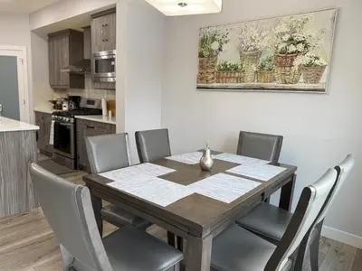 a dining room table and chairs in a kitchen at Family Friendly GarageFireplace Sleeps 8 in Edmonton