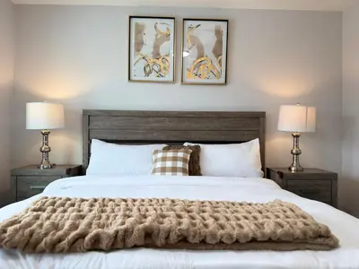 a bedroom with a large white bed with two lamps at Family Friendly GarageFireplace Sleeps 8 in Edmonton