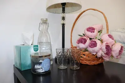 a table with a basket of flowers and a bottle of water at Cozy home in Calgary