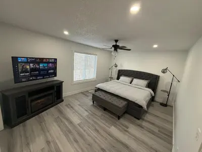 a bedroom with a bed and a flat screen tv at Family-Friendly Home in the Heart of Chestermere in Chestermere