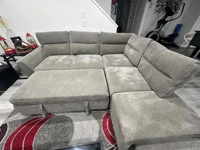 a gray couch sitting in a living room at Family-Friendly Home in the Heart of Chestermere in Chestermere