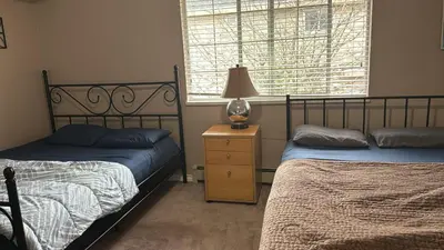 a bedroom with two beds and a lamp on a night stand at North Delta Budget Stay - Scott Road - Free Parking & Fast WiFi in Delta
