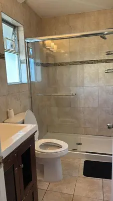 a bathroom with a toilet and a shower and a sink at Budget Stay Near Scott Road - Transit, Free Parking & Fast WiFi in Delta