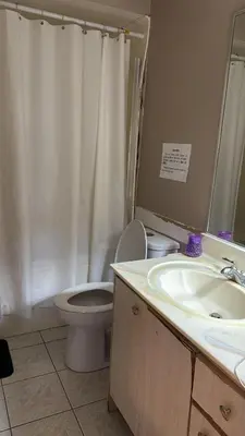 a bathroom with a toilet and a sink at Budget Stay Near Scott Road - Transit, Free Parking & Fast WiFi in Delta