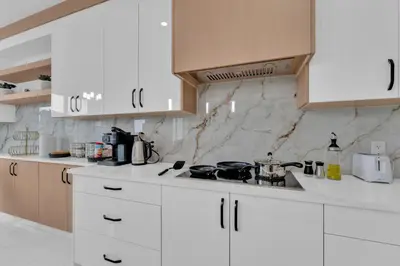 a white kitchen with white cabinets and a stove at 3 Bedrooms Brand New Luxury Home Close to Amenity in Leduc