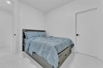 a white bedroom with a bed with a blue comforter at 3 Bedrooms Brand New Luxury Home Close to Amenity in Leduc