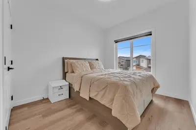 a white bedroom with a bed and a window at 3 Bedrooms Brand New Luxury Home Close to Amenity in Leduc