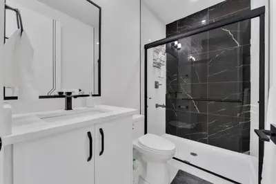a white bathroom with a shower and a toilet at 3 Bedrooms Brand New Luxury Home Close to Amenity in Leduc