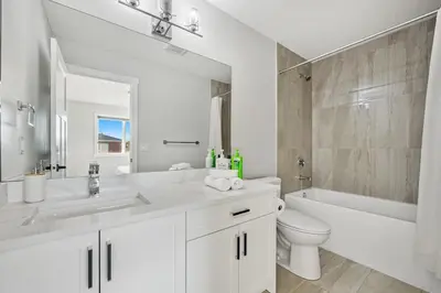 a white bathroom with a sink and a tub and a toilet at Spacious 8 Bedroom Family Retreat in Calgary