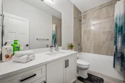 a white bathroom with a sink and a toilet at Spacious 8 Bedroom Family Retreat in Calgary