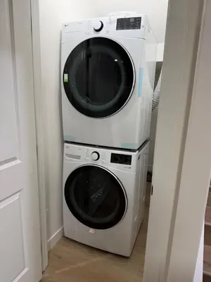a washer and dryer stacked on top of each other at 2-bedroom suite close to Amenities and Airport with on pad parking in Leduc