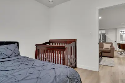 a bedroom with a bed and a couch and a chair at 2-bedroom suite close to Amenities and Airport with on pad parking in Leduc