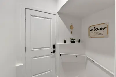 an open white door in a white hallway at 2-bedroom suite close to Amenities and Airport with on pad parking in Leduc