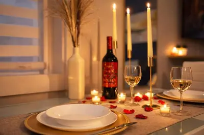 a table with plates and glasses of wine and candles at Ocean-Inspired Art Suite in Langford