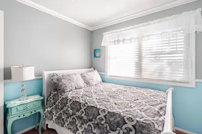 a small bedroom with a bed and a window at Harmony House short term rental in Okotoks