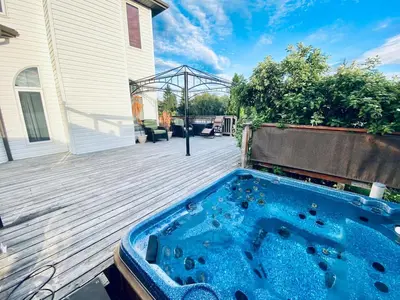 a hot tub on the deck of a house at Spacious 3BR Retreat w-Hot Tub Ravine Sleeps 9 in Edmonton