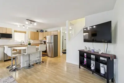 a kitchen and living room with a table and a refrigerator at Renovated Cozy Family Home Spacious, Modern in Edmonton