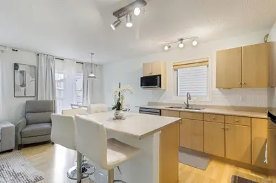 a kitchen and living room with a table and chairs at Renovated Cozy Family Home Spacious, Modern in Edmonton