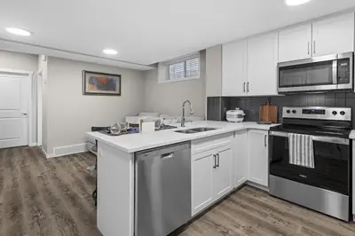 a kitchen with white cabinets and a sink at Private Guest Suite in SE Calgary 5 minutes to South Health Campus & Seton YMCA in Calgary