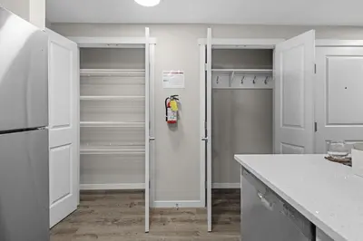 a kitchen with white cabinets and a refrigerator at Private Guest Suite in SE Calgary 5 minutes to South Health Campus & Seton YMCA in Calgary