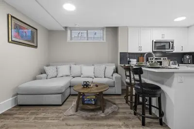 a living room with a couch and a kitchen at Private Guest Suite in SE Calgary 5 minutes to South Health Campus & Seton YMCA in Calgary
