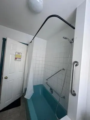 a bathroom with a shower with a blue tub at 3 Private rooms with built-in closet & desk in Edmonton
