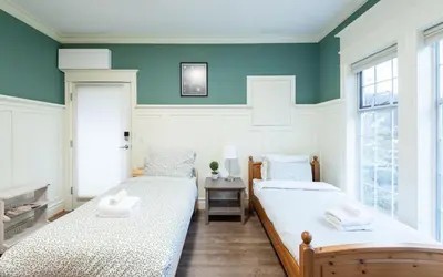 two beds in a room with blue walls and windows at 3Beds Ground-Level Private Suite in Burnaby in Burnaby