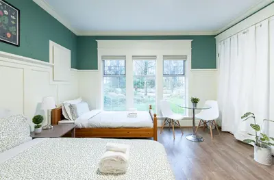 a bedroom with two beds and a table and chairs at 3Beds Ground-Level Private Suite in Burnaby in Burnaby