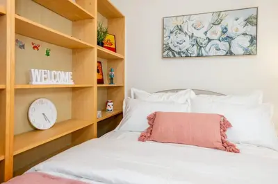 a bedroom with a bed with a clock on a shelf at Central Van 3BR Upper Suite - Near Skytrain in Vancouver