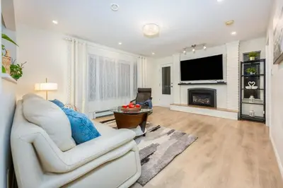 a living room with a white couch and a fireplace at Central Van 3BR Upper Suite - Near Skytrain in Vancouver