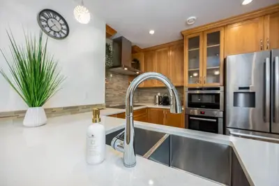 a kitchen with a sink and a clock on the wall at Central Van 3BR Upper Suite - Near Skytrain in Vancouver