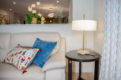 a white couch with a pillow and a lamp on a table at Central Van 3BR Upper Suite - Near Skytrain in Vancouver