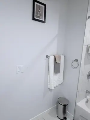 a white bathroom with a towel rack and a sink at The Cozy Spot in Edmonton