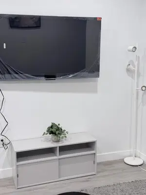 a white entertainment center with a tv on a white wall at The Cozy Spot in Edmonton