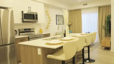 a kitchen with a table and chairs in a kitchen at A Touch of the Tropics-Cozy Warm 2BR Stay in Edmonton