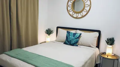 a bedroom with a bed with a mirror on the wall at A Touch of the Tropics-Cozy Warm 2BR Stay in Edmonton