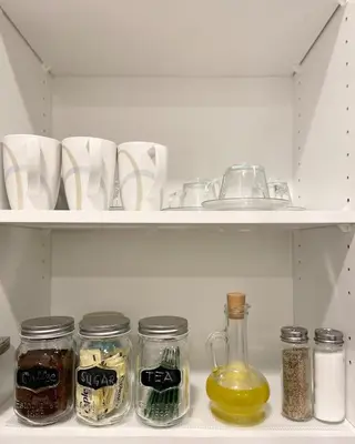 a shelf with jars of food and a sink in a refrigerator at A Touch of the Tropics-Cozy Warm 2BR Stay in Edmonton