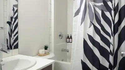 a bathroom with a sink and a toilet and a shower at A Touch of the Tropics-Cozy Warm 2BR Stay in Edmonton